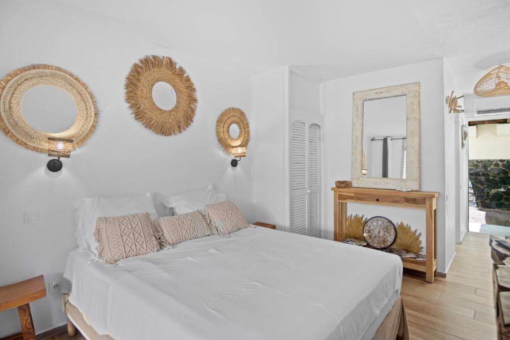 a bedroom with a bed and mirrors on the wall at Studio Sunshine in Le Diamant
