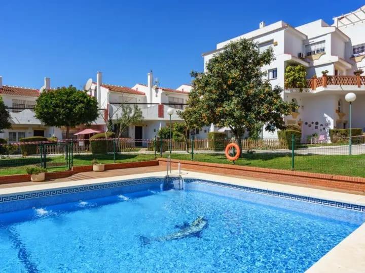 a swimming pool in front of a building at Chalet Baena Torremolinos in Torremolinos
