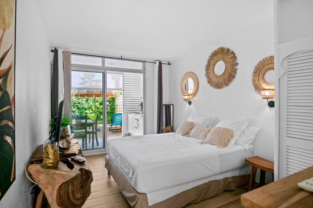 a bedroom with a bed and a sliding glass door at Studio Sunshine in Le Diamant