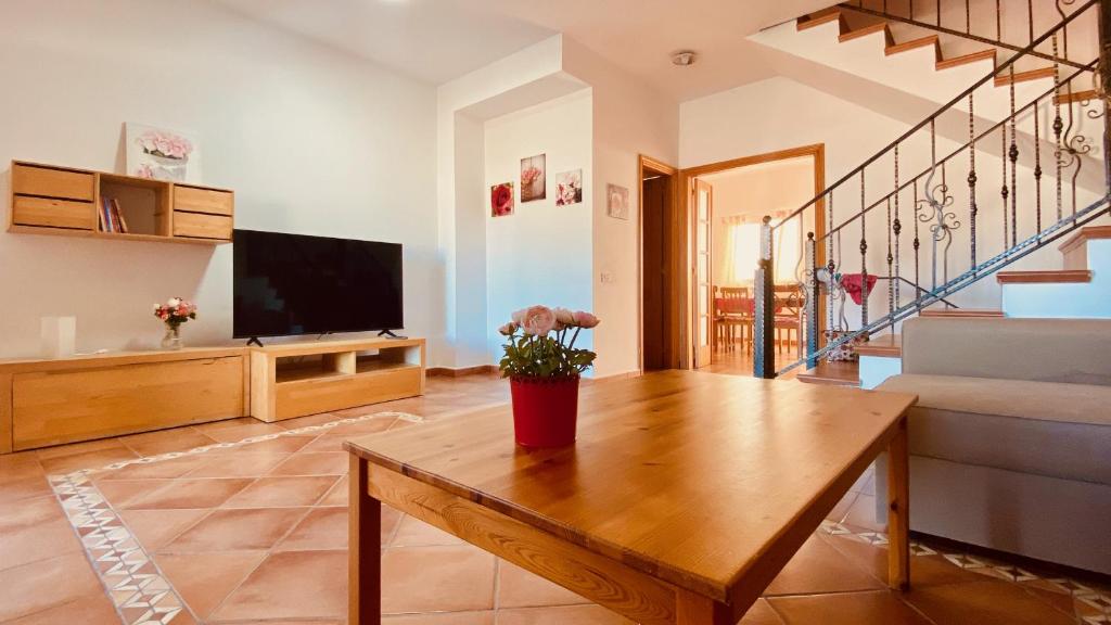 een woonkamer met een tafel en een televisie bij Casa de Las Flores in Cruce de Arinaga