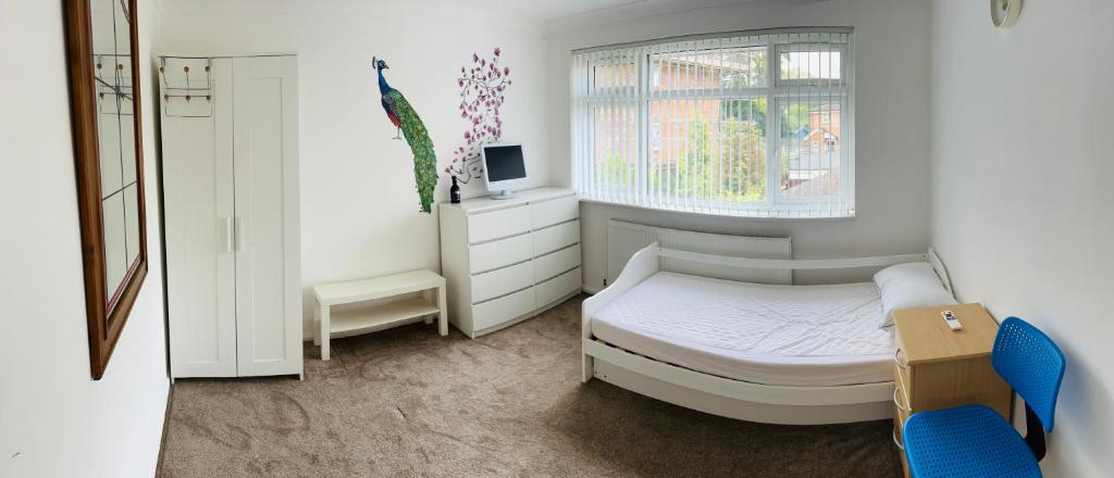 a small bedroom with a bed and a window at Large guest Room in Maidenhead