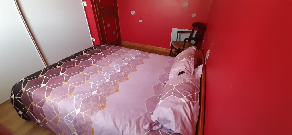 - une chambre rouge avec un lit avec moustiquaire dans l'établissement Les Sabots D'Angélina, à Saint-Bonnet-lʼEnfantier
