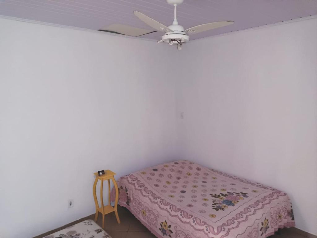 a bedroom with a bed and a ceiling fan at casa Amarela in Tamoios