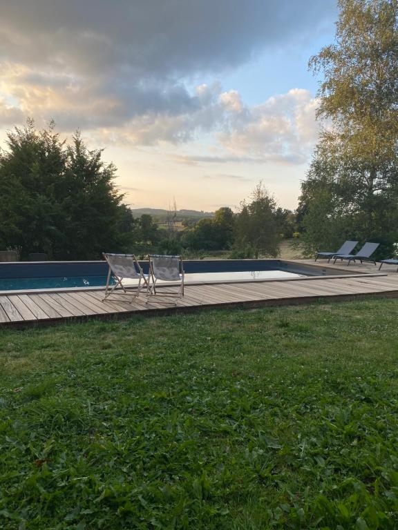 a row of chairs sitting next to a swimming pool at Une pause en Corrèze in Sarroux