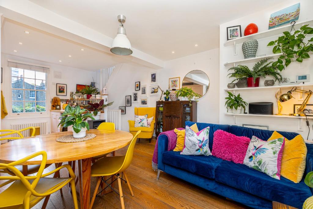 a living room with a blue couch and a table at Amazing 3-Storey 2BR House, Patio, 5 min Limehouse in London