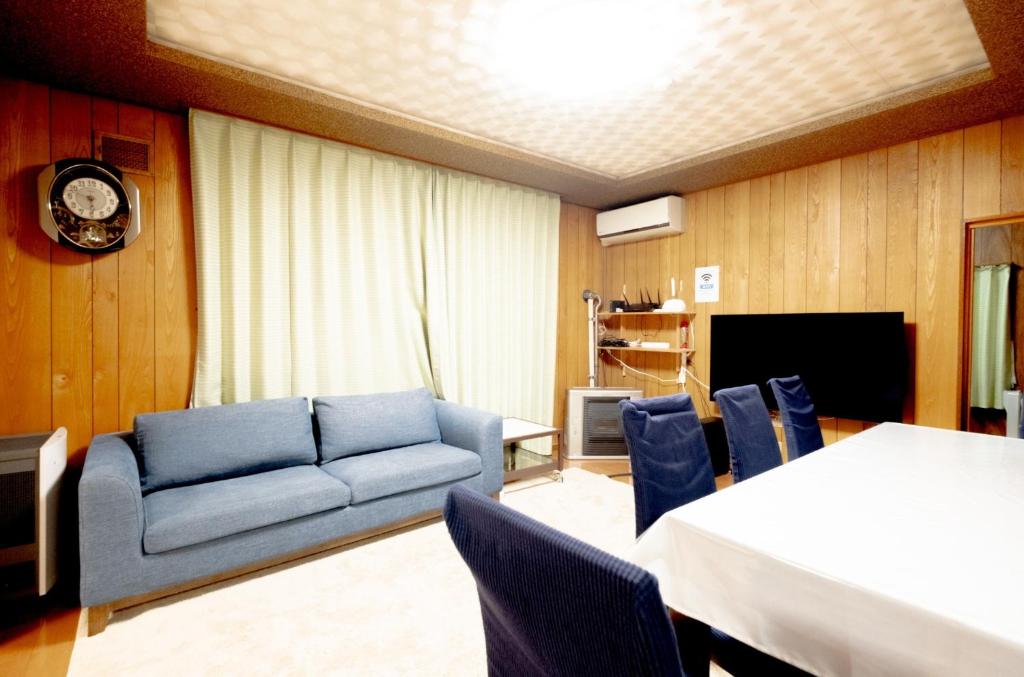 - un salon avec un canapé, une table et des chaises dans l'établissement Furano Garden House - Vacation STAY 15463, à Furano