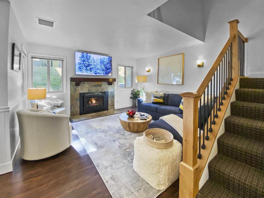 a living room with a staircase and a fireplace at 37C Hidden Creek Mountain Getaway! condo in Park City