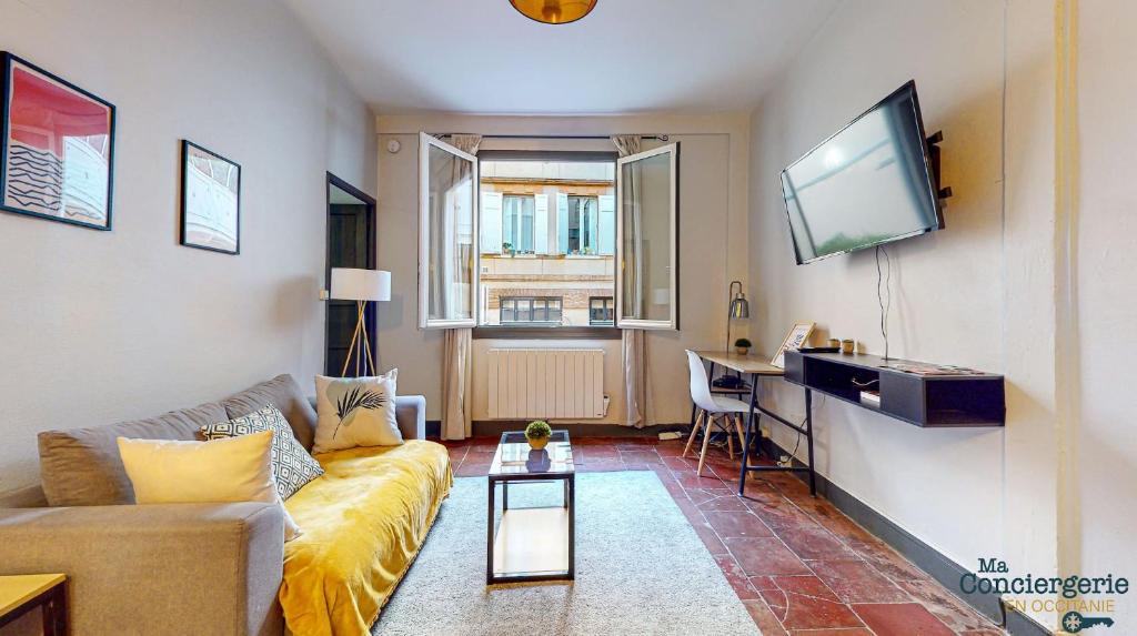 un salon avec un canapé et une télévision à écran plat dans l'établissement COUTELIERS - Hypercentre Carmes - Métro à 4min, à Toulouse