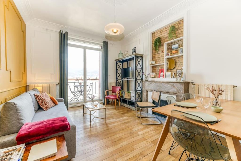 un salon avec un canapé et une table dans l'établissement Esprit vintage: lit double, balcon, wifi, équipé+, à Grenoble