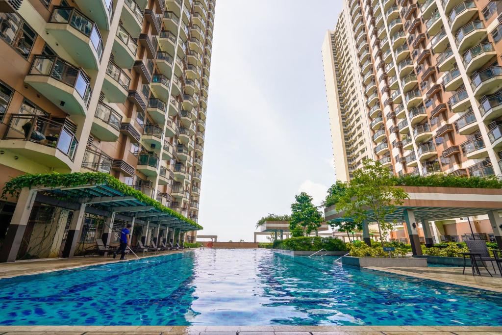 a swimming pool in the middle of two tall buildings at The Radiance Manila Bay Studio in Manila