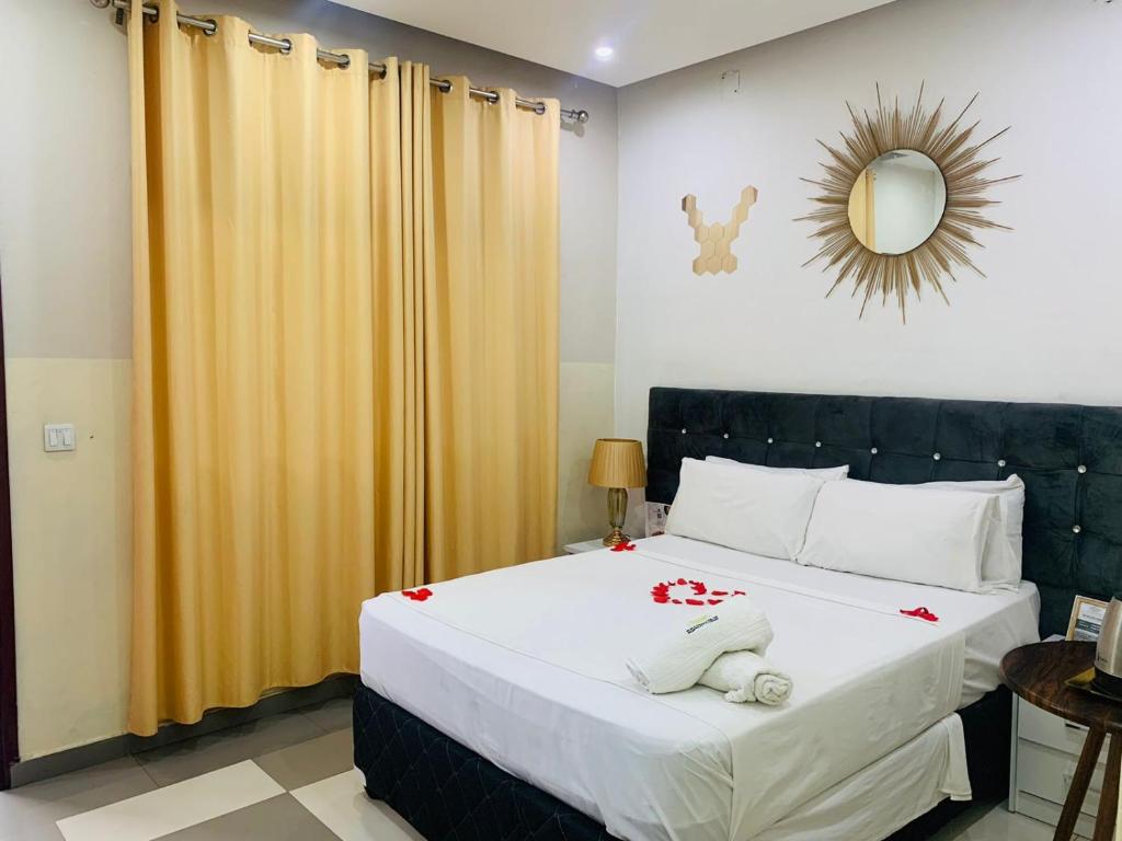a bedroom with a bed with white sheets and a mirror at 40 40 Accommodation in Matola