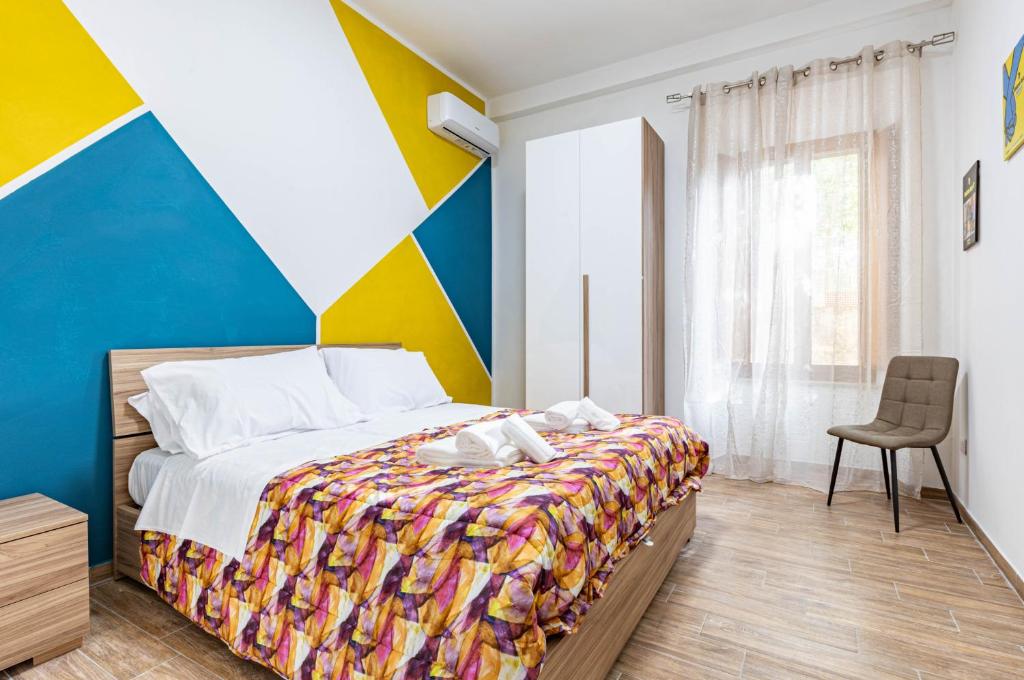 um quarto com uma cama com uma parede colorida em Casa di Angelo Vibrant Apartment em Perugia