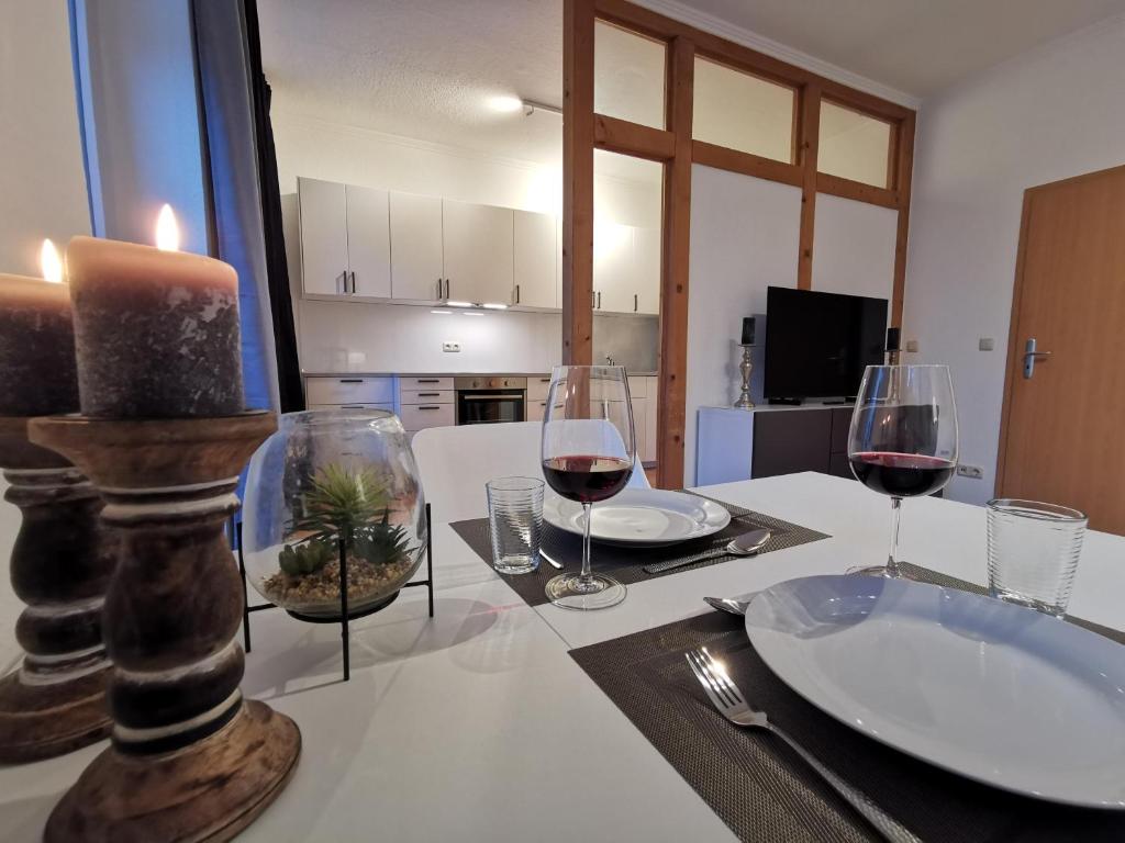 a table with wine glasses and a candle on it at Apartment "Matt Rose" Rostock in Rostock