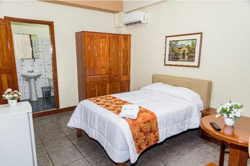 1 dormitorio con 1 cama y baño con lavamanos en Hotel Oro Verde & Suites, en Iquitos