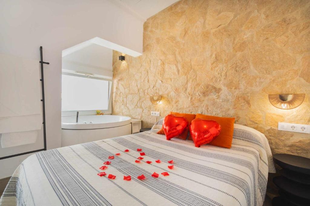 a bedroom with a bed with red pillows on it at Jacuzzi Amanecer de Plata Decoración Romántica in Chiclana de la Frontera