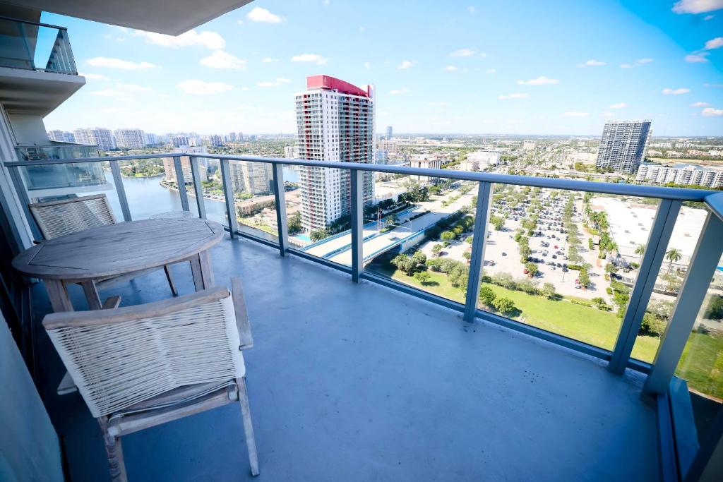 a table and chair on a balcony with a view of the city at Zen Beach House Luxury 1-Bedroom Intracoastal Views in Hollywood