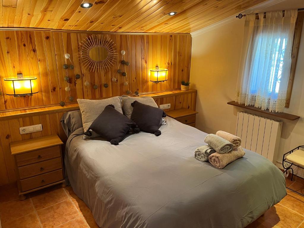 1 dormitorio con 1 cama grande y paredes de madera en CAN VALERO, en Bagá