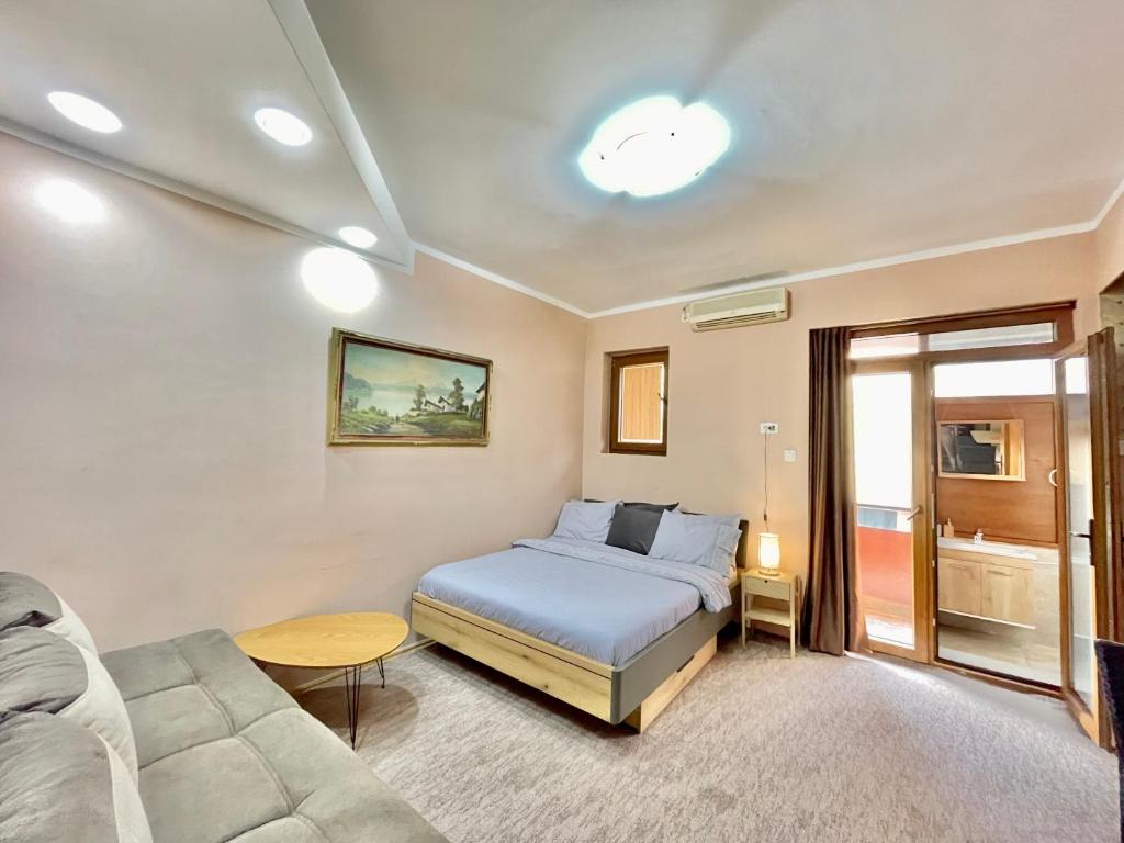 a bedroom with a bed and a couch at Apartment Centar in Podgorica