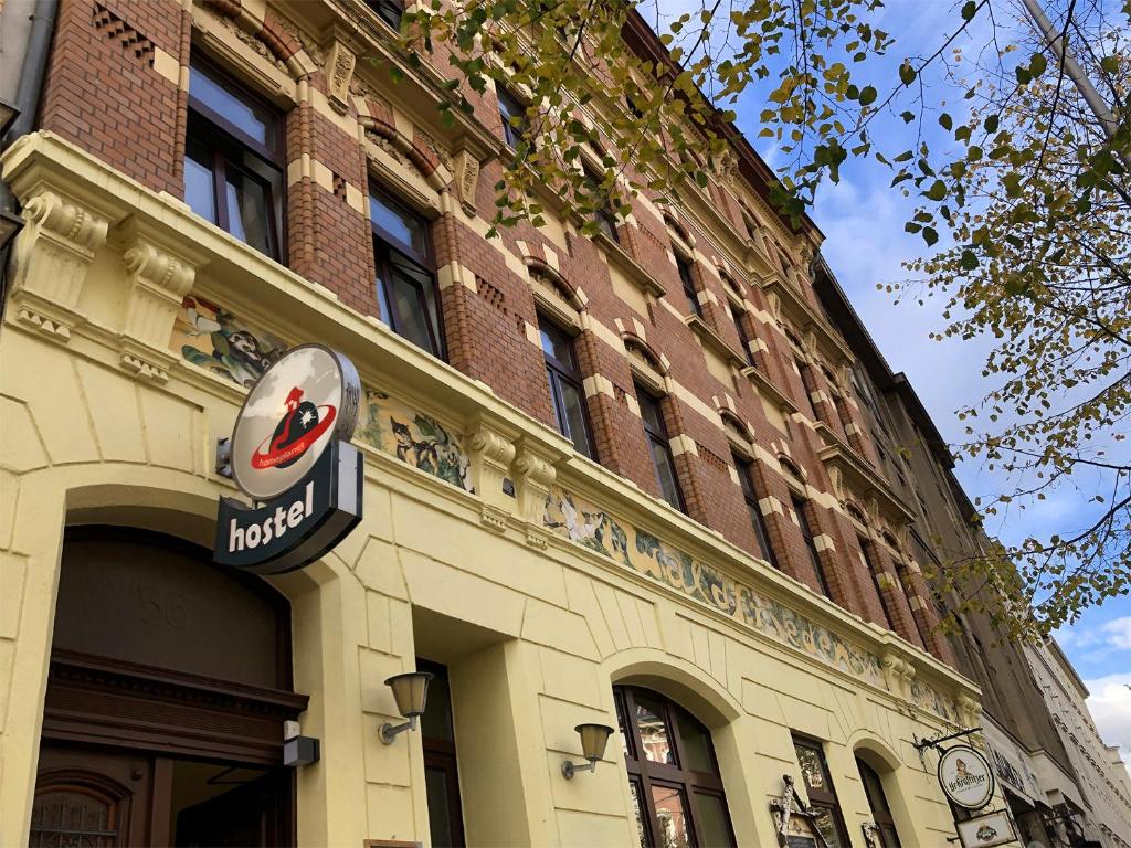 a building with a hotel sign on the side of it at Homeplanet Hostel in Leipzig