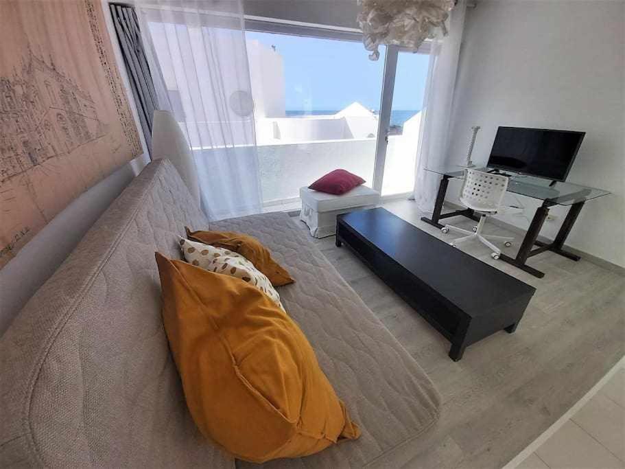 a living room with a couch and a table at BREEZE VIEW house by the sea in Corralejo