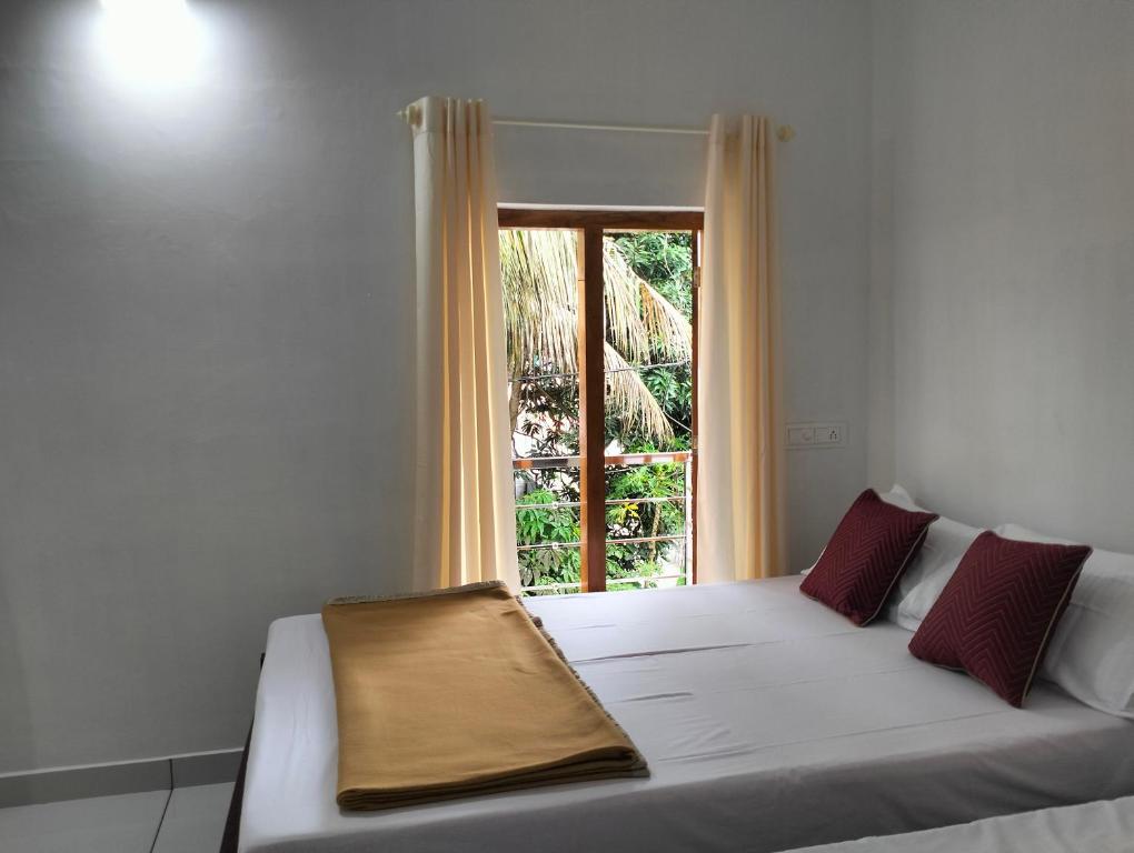 Posto letto in camera con finestra di Guestland Homestay a Cochin