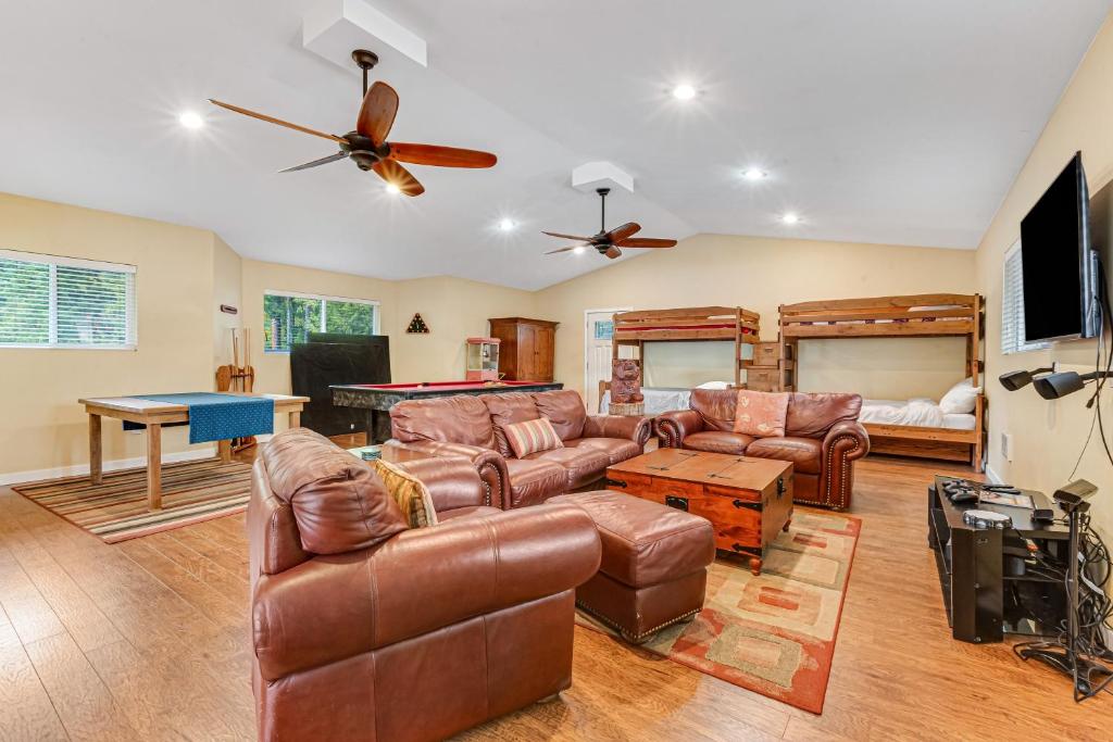 sala de estar con muebles de cuero y mesa de billar en Summit Lake Guesthouse, en Kamilche