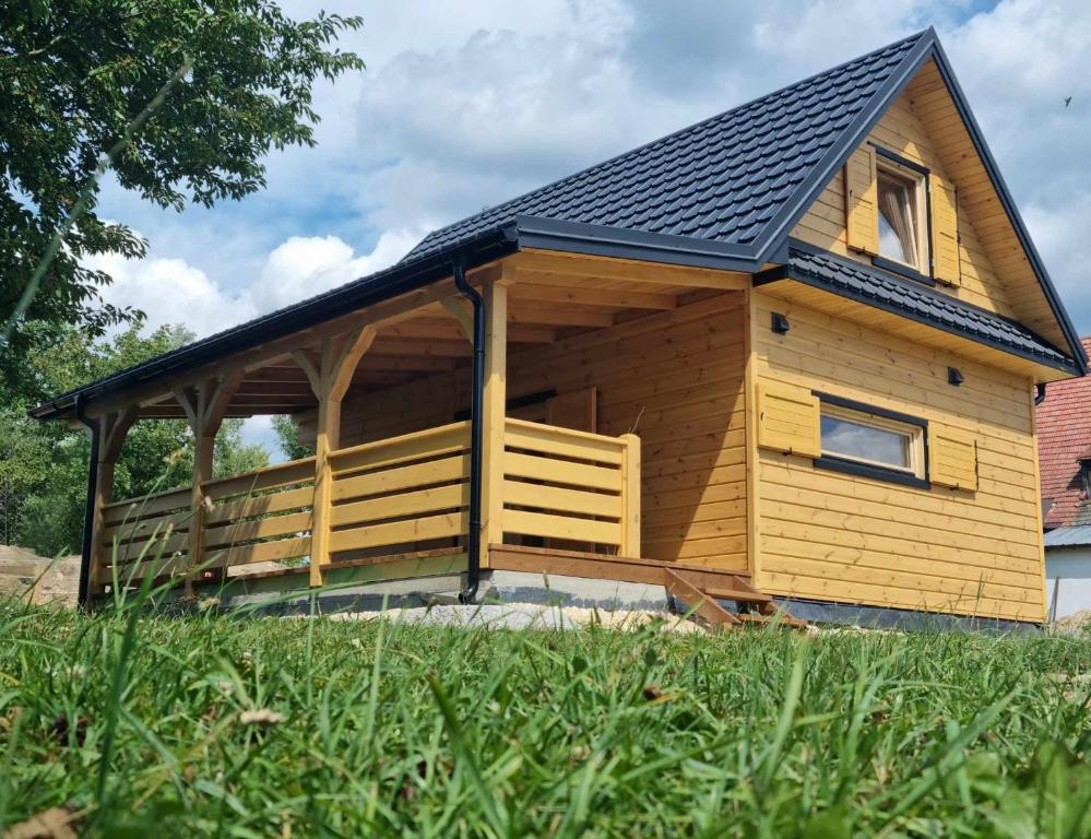 una cabaña de madera con techo de gambrel en BAJKA-Domek na wsi en Domaszków