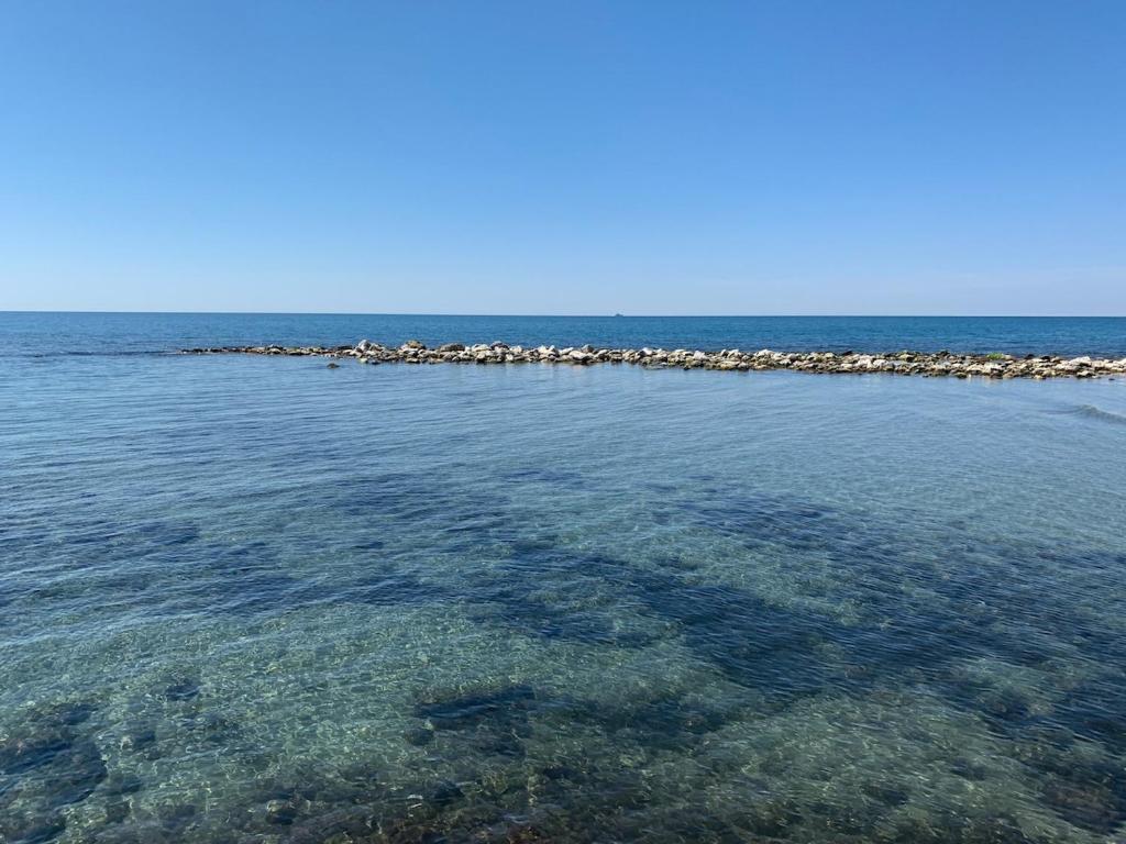 une grande masse d'eau avec des rochers dans l'eau dans l'établissement Holiday Home Il Pontile in Marina di Massa, apartments with private outdoor area, just 400 meters from the sea, à Massa