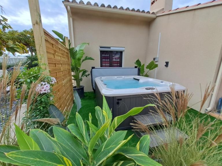 a hot tub in the yard of a house at Maison individuelle plain pied avec Spa en option in Perpignan
