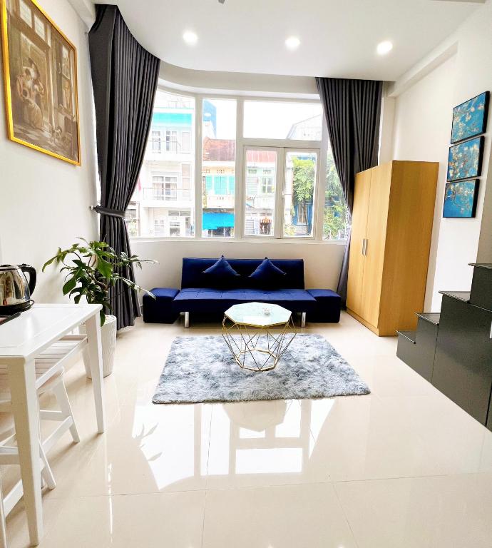 a living room with a blue couch and a table at Lucky Hotel Apartment in Ho Chi Minh City