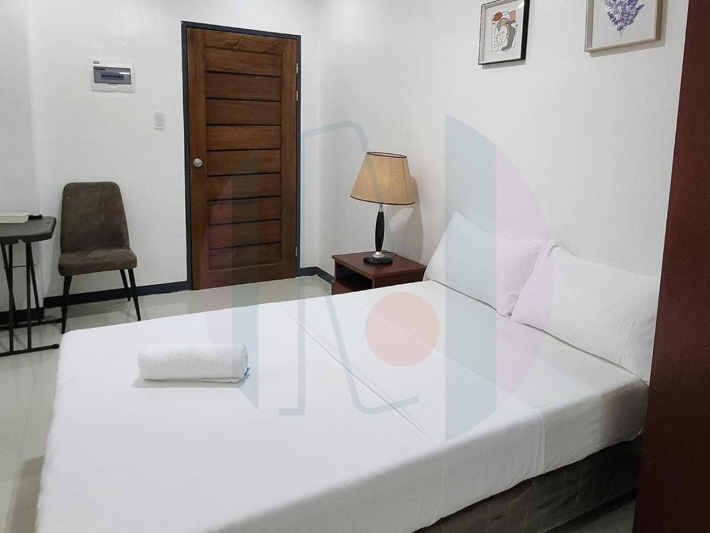 - une chambre dotée d'un lit blanc avec une lampe et une chaise dans l'établissement RiCres Hometel Standard R5, à Babak