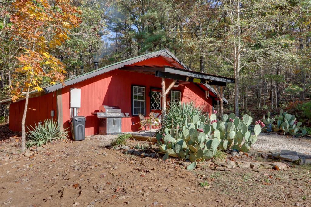 um barracão vermelho com um fogão e cactos à sua frente em Bunkhouse-Style Studio in Elkins Near ATV Trails! em Elkins