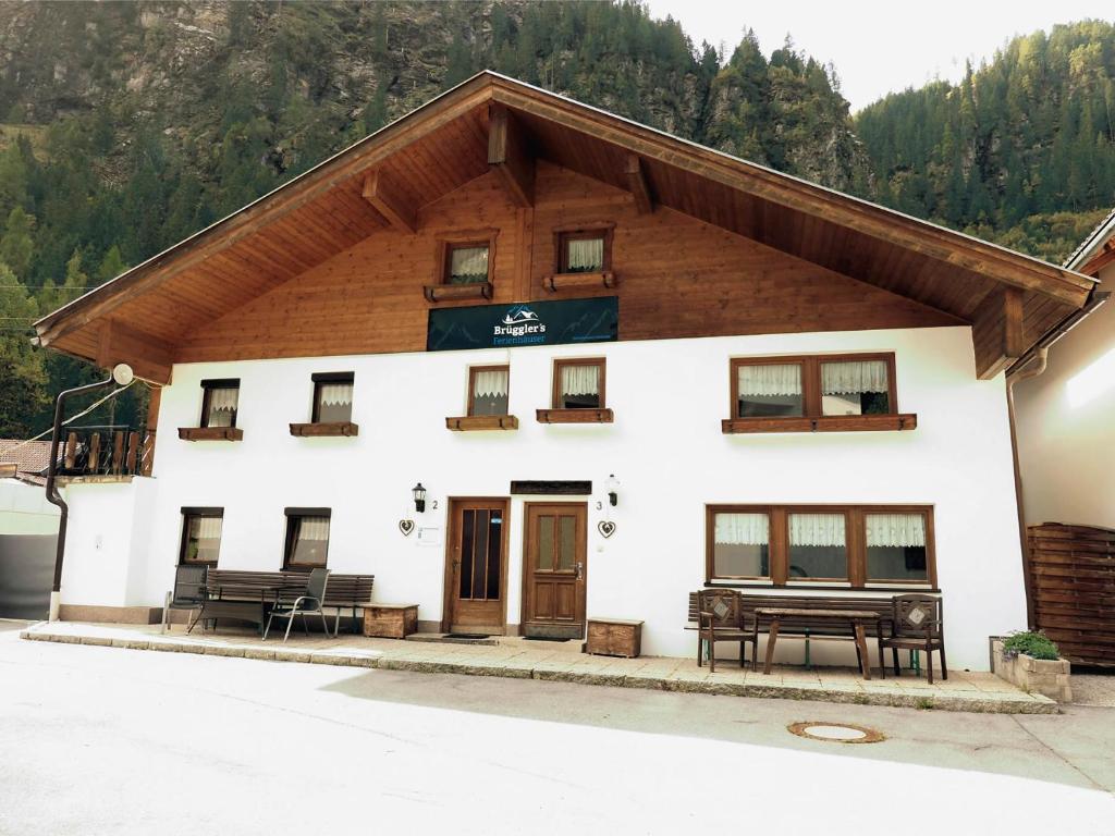 ein Gebäude mit einer Bank davor in der Unterkunft Brügglers Ferienhäuser in Sankt Leonhard im Pitztal