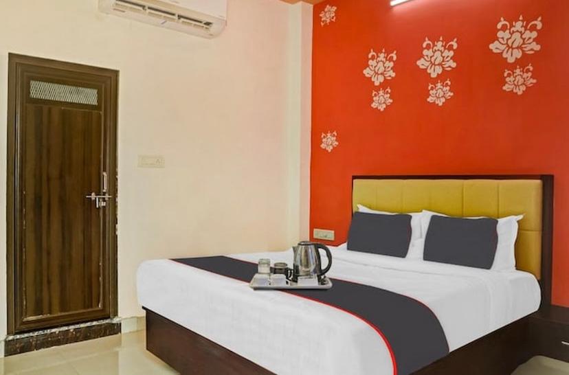 Hotel Sanwariya Residency في أودايبور: غرفة نوم بسرير كبير وبجدار احمر