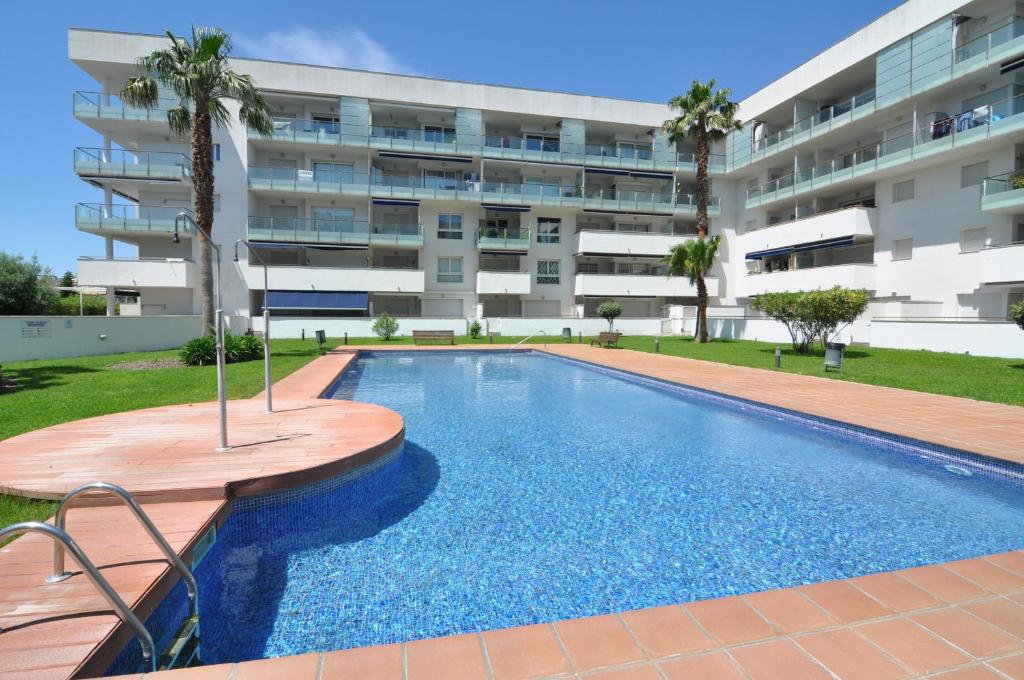 una piscina frente a un edificio de apartamentos en RNET - Portomar Plus Roses en Roses