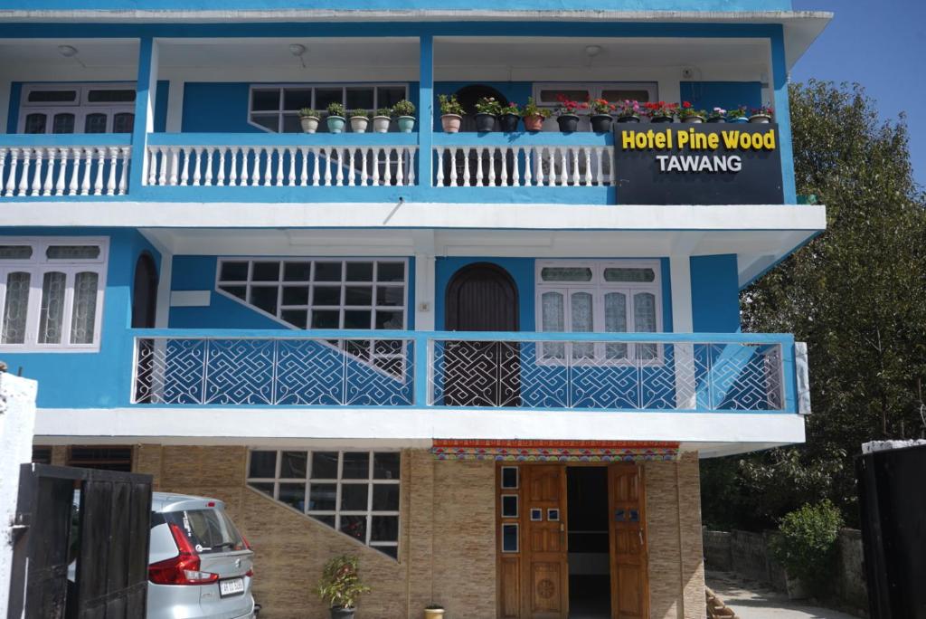 a blue and white house with a balcony at Hotel PineWood Tawang in Tawang