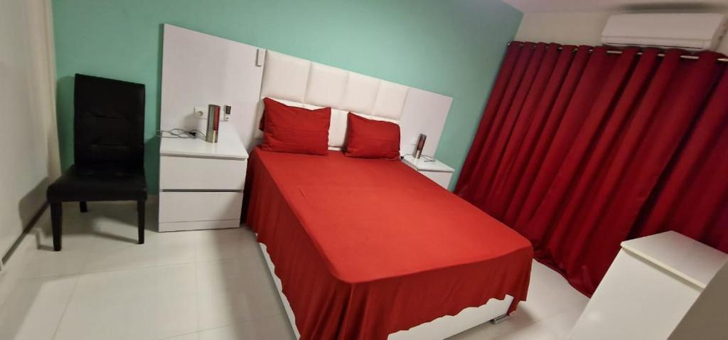 um quarto com uma cama vermelha e uma cortina vermelha em SUITES-HOME, CIDADELA em Praia