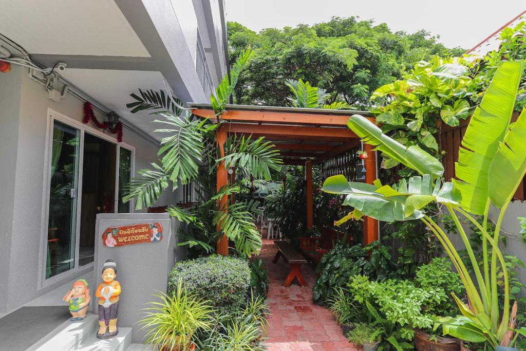 una casa con plantas y estatuillas fuera de ella en The Phen House, en Hua Hin