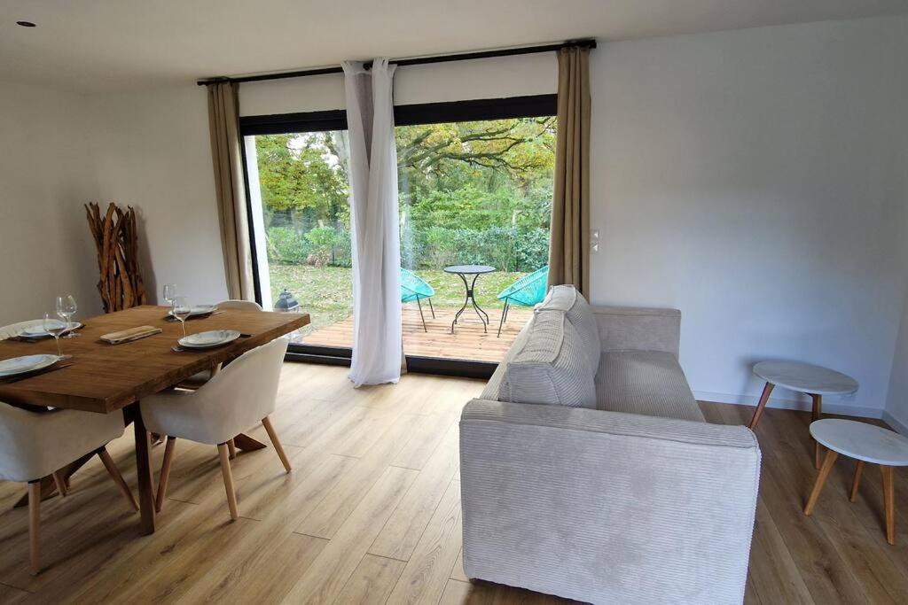 uma sala de estar com uma mesa de madeira e uma sala de jantar em Gîte Les Bruyères em Janville
