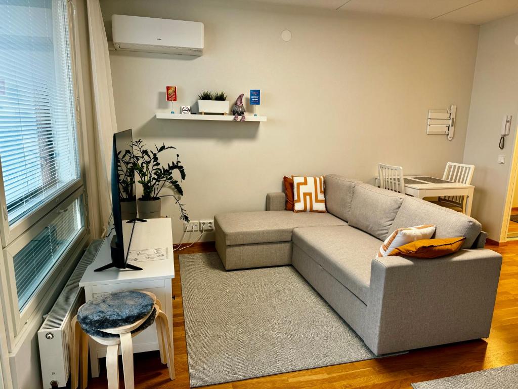 ein Wohnzimmer mit einem Sofa und einem Tisch in der Unterkunft Top floor flat with sauna, A/C & free parking in Vantaa