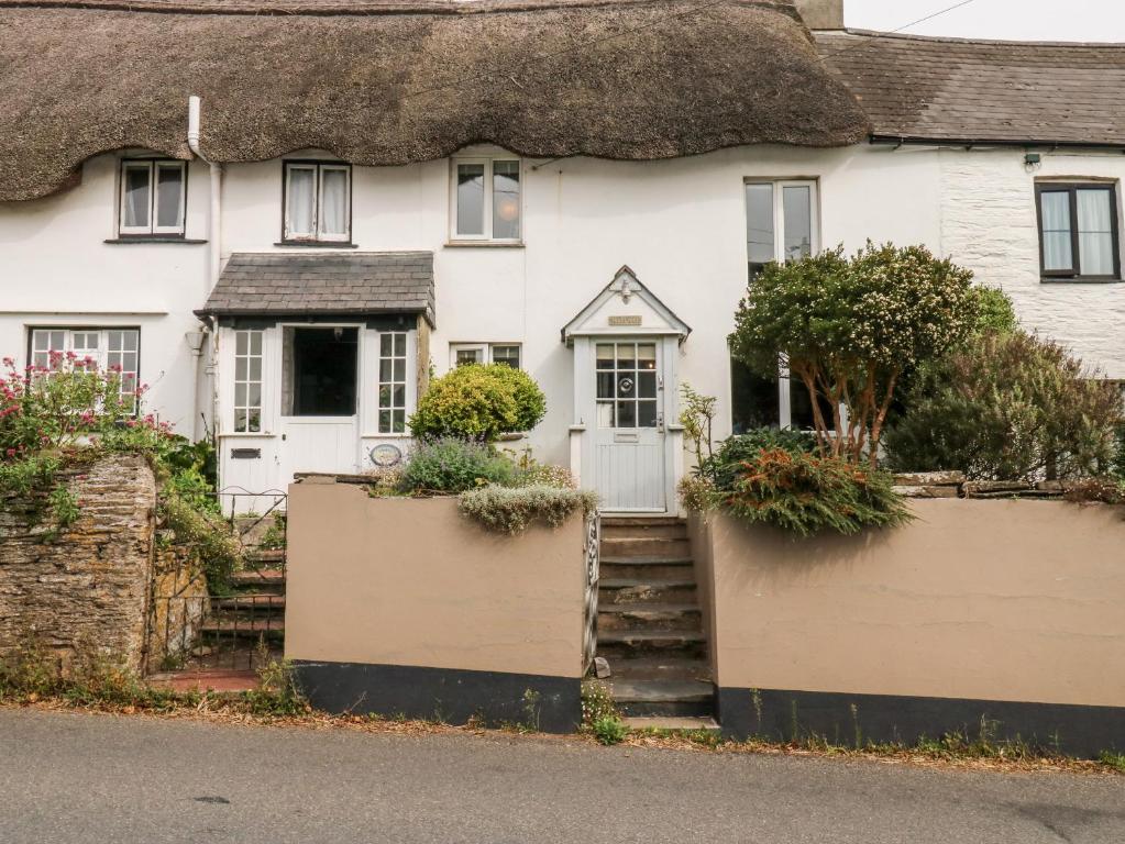 uma casa branca com telhado de palha em Alexander's Cottage em Kingsbridge