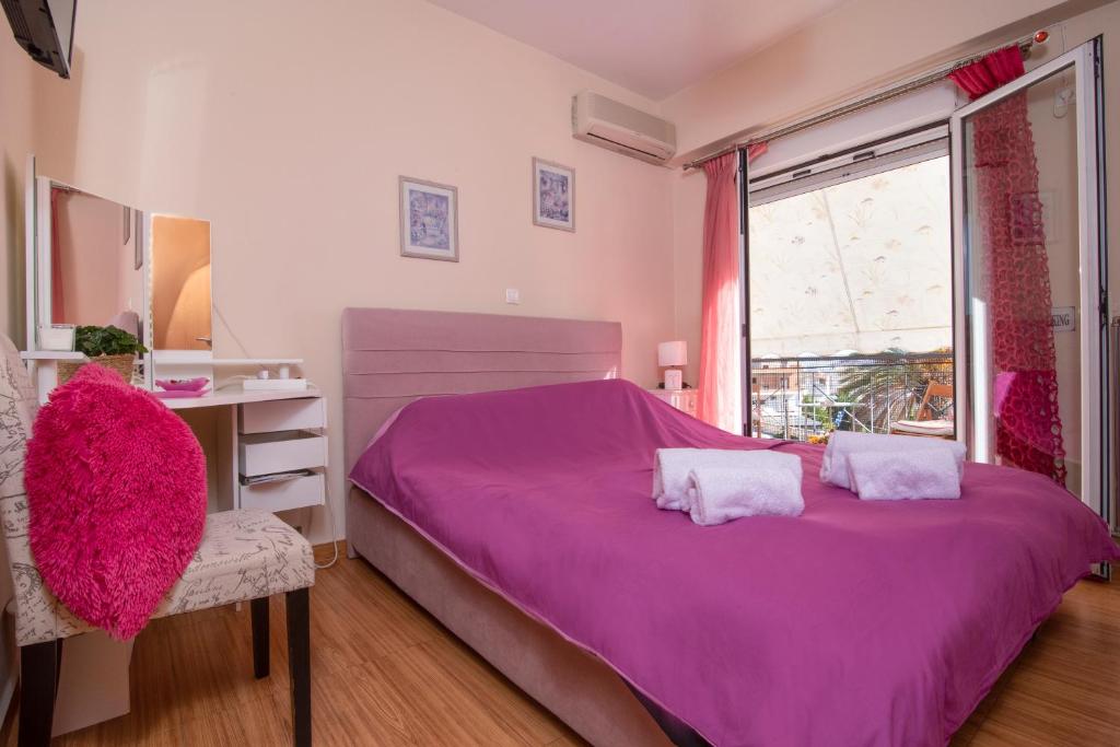 - une chambre rose avec un grand lit et une fenêtre dans l'établissement Maria's Double Room, à Spáta