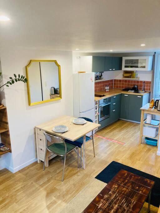 une cuisine avec des armoires bleues et une table et des chaises dans l'établissement Le KÊREL - Super duplex - Rennes, à Saint-Jacques-de-la-Lande
