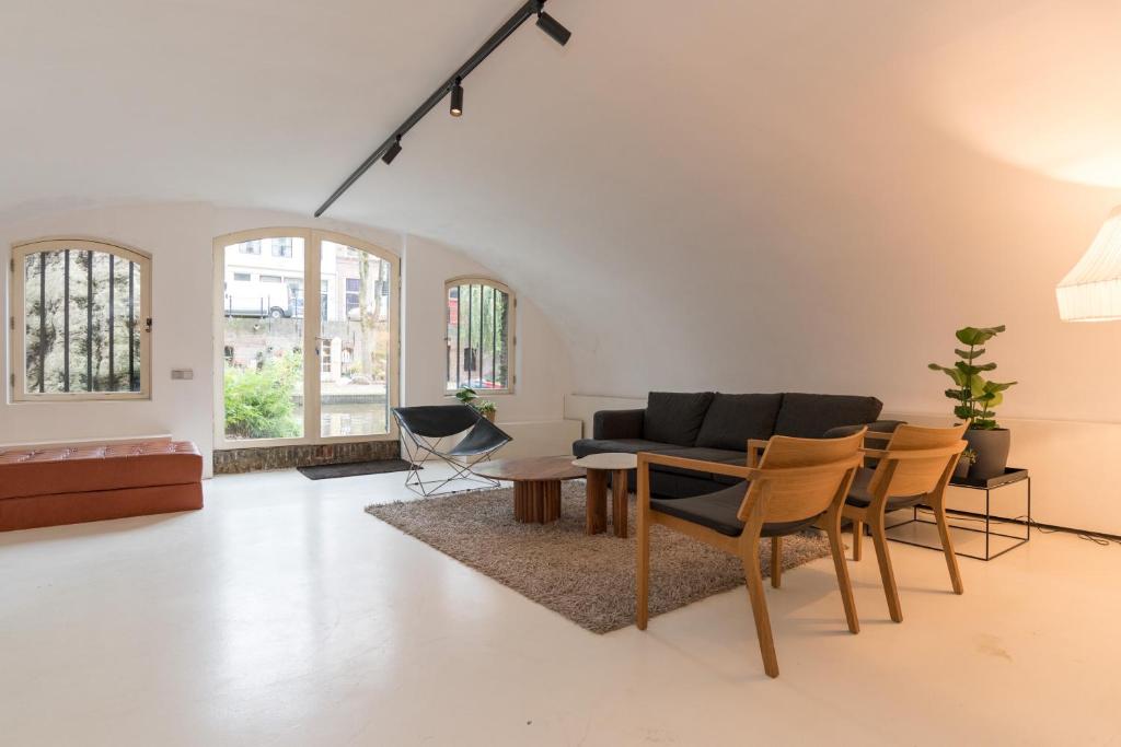 sala de estar con sofá, mesa y sillas en Wellness Apartment on the Wharf Utrecht, en Utrecht