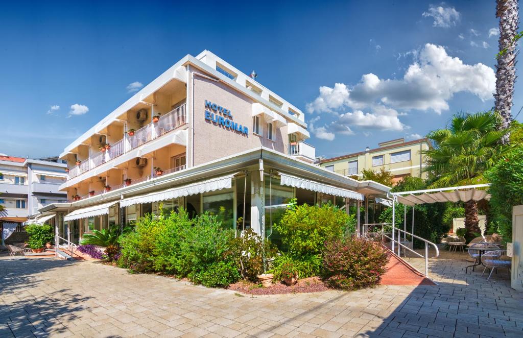 budynek hotelowy z roślinami przed nim w obiekcie Hotel Euromar w mieście Marina di Massa