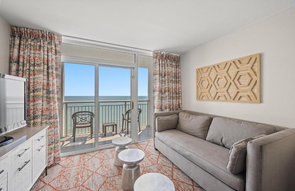 a living room with a couch and a view of the ocean at Camelot By The Sea 1206 in Myrtle Beach