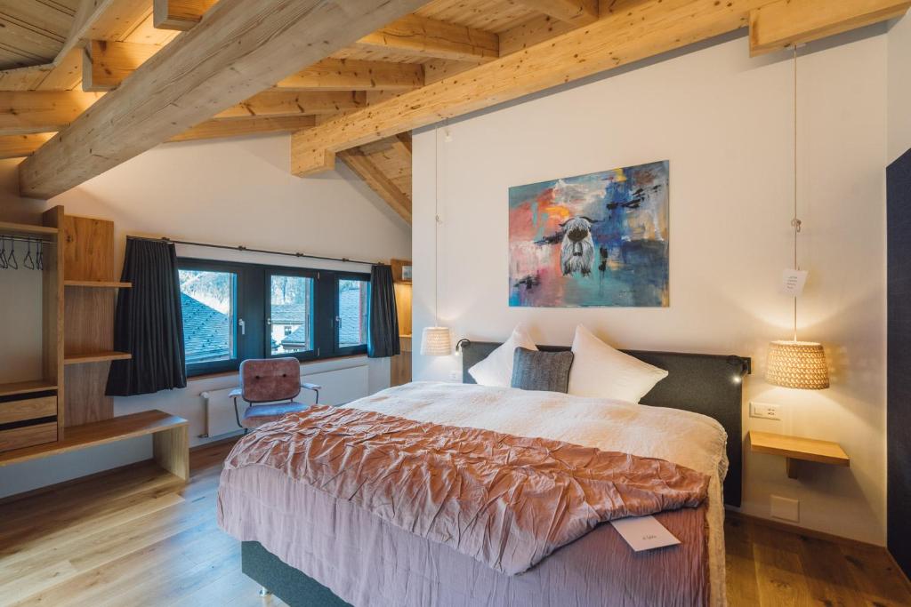 a bedroom with a large bed in a room with wooden ceilings at Hotel Walliserkanne in Grächen