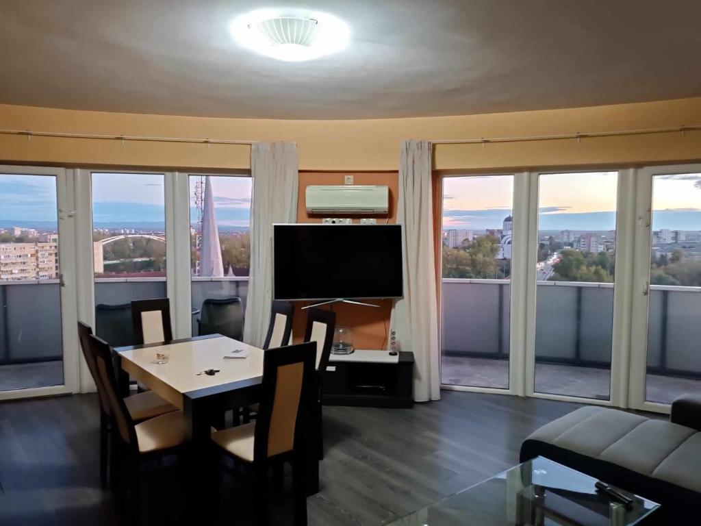 a living room with a table and a television at Panorama Apartament Plaza Tower in Satu Mare