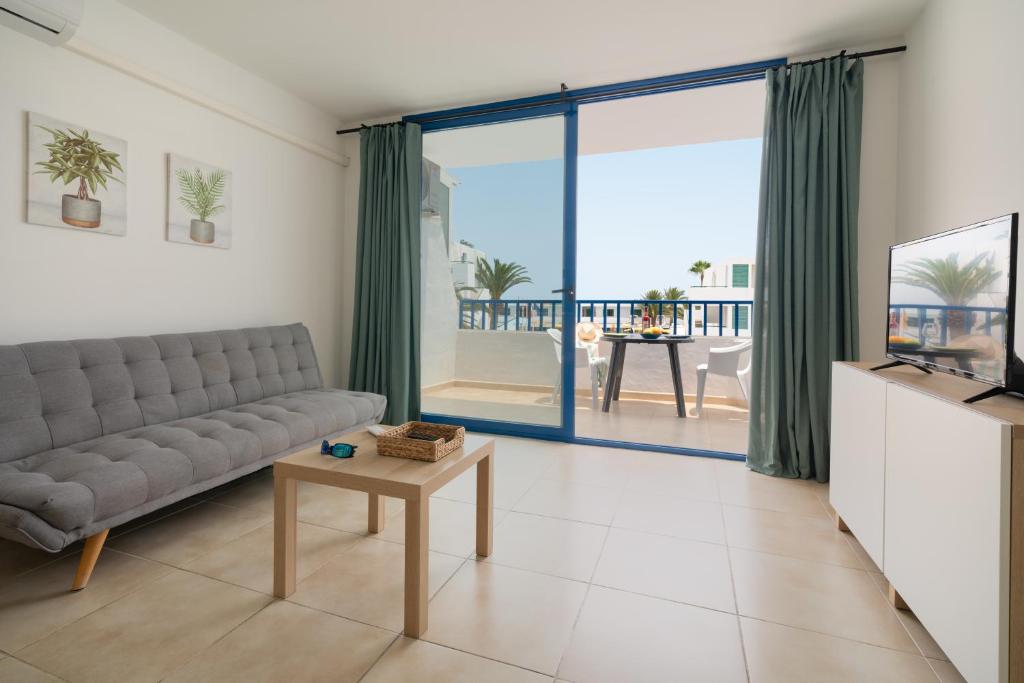 a living room with a couch and a table at Sabbia Suites Pleamar in Puerto del Carmen