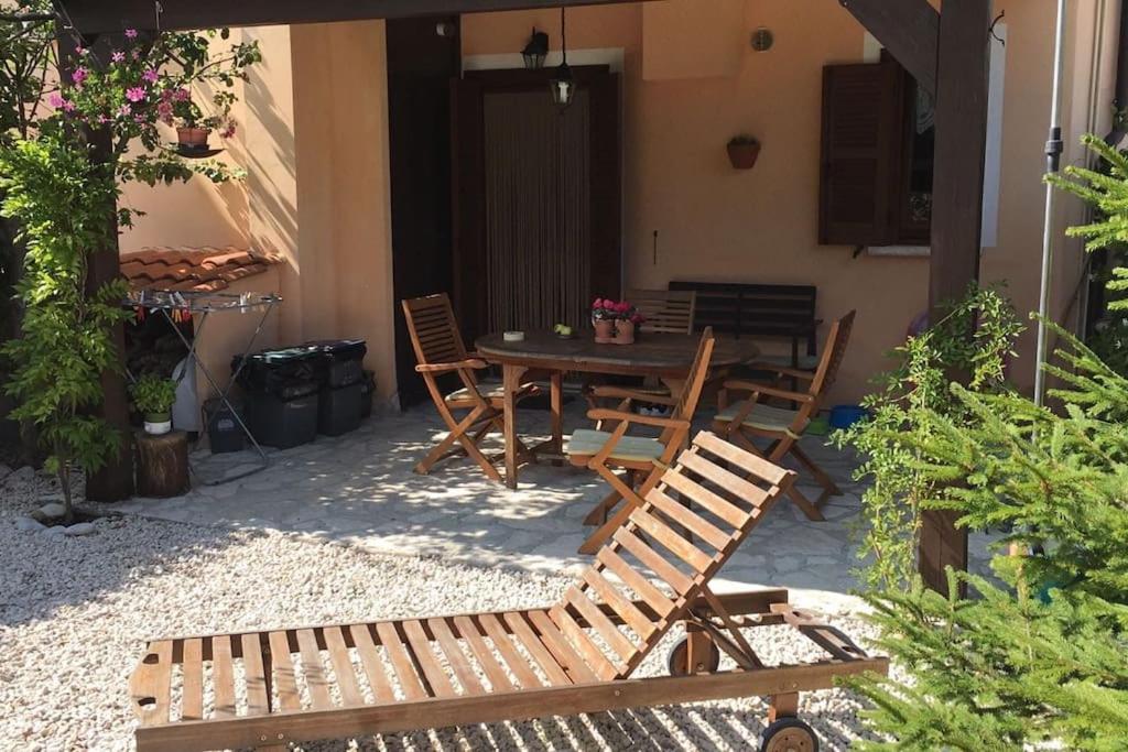 un patio con tavolo e sedie in legno di casa di Alice, castel del giudice a Isernia